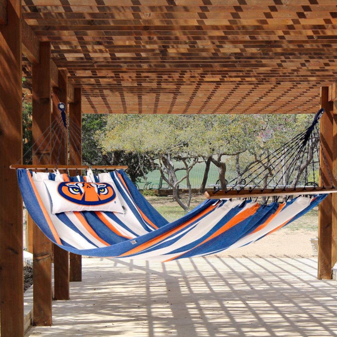 Striped Auburn Tigers hammock with a pillow on a wooden deck patio