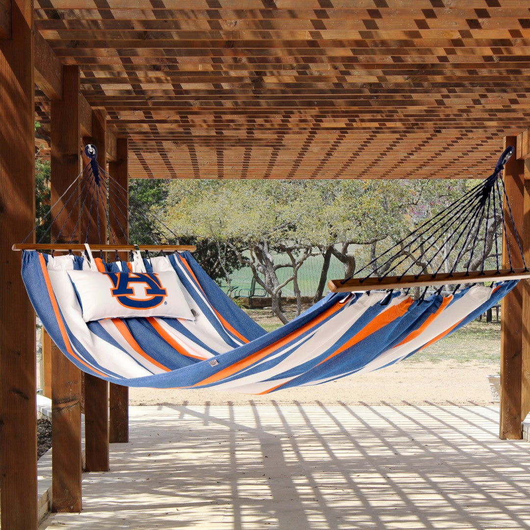 Colorful striped Auburn logo hammock hanging from a wooden pergola outdoors patio