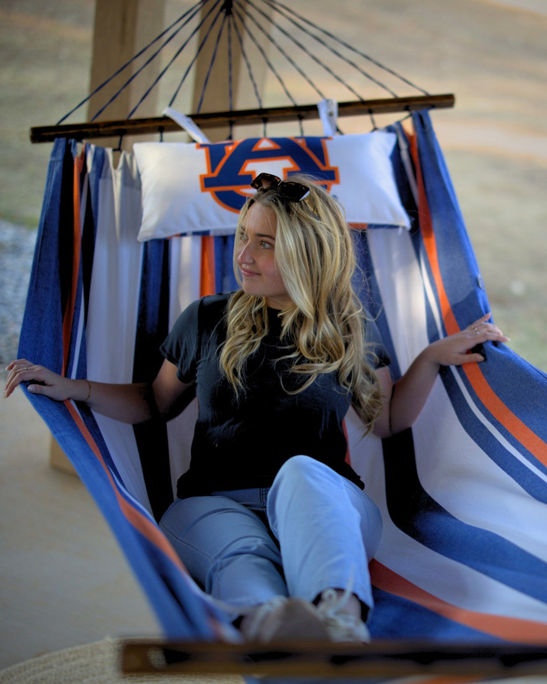 Woman sitting in a hammock with Auburn University-themed fabric