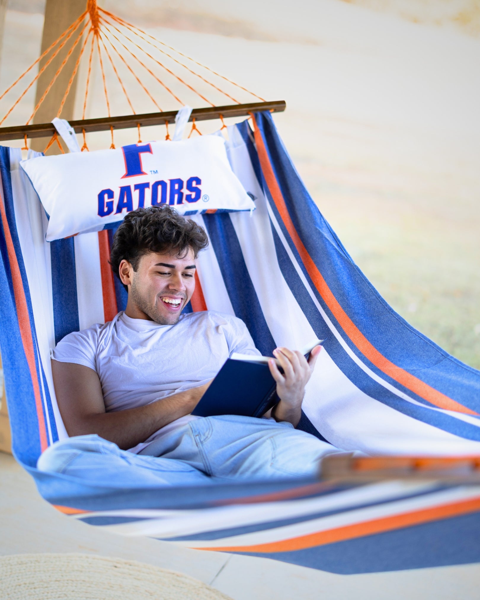 Person reading a book in a colorful hammock with 'Gators' branding