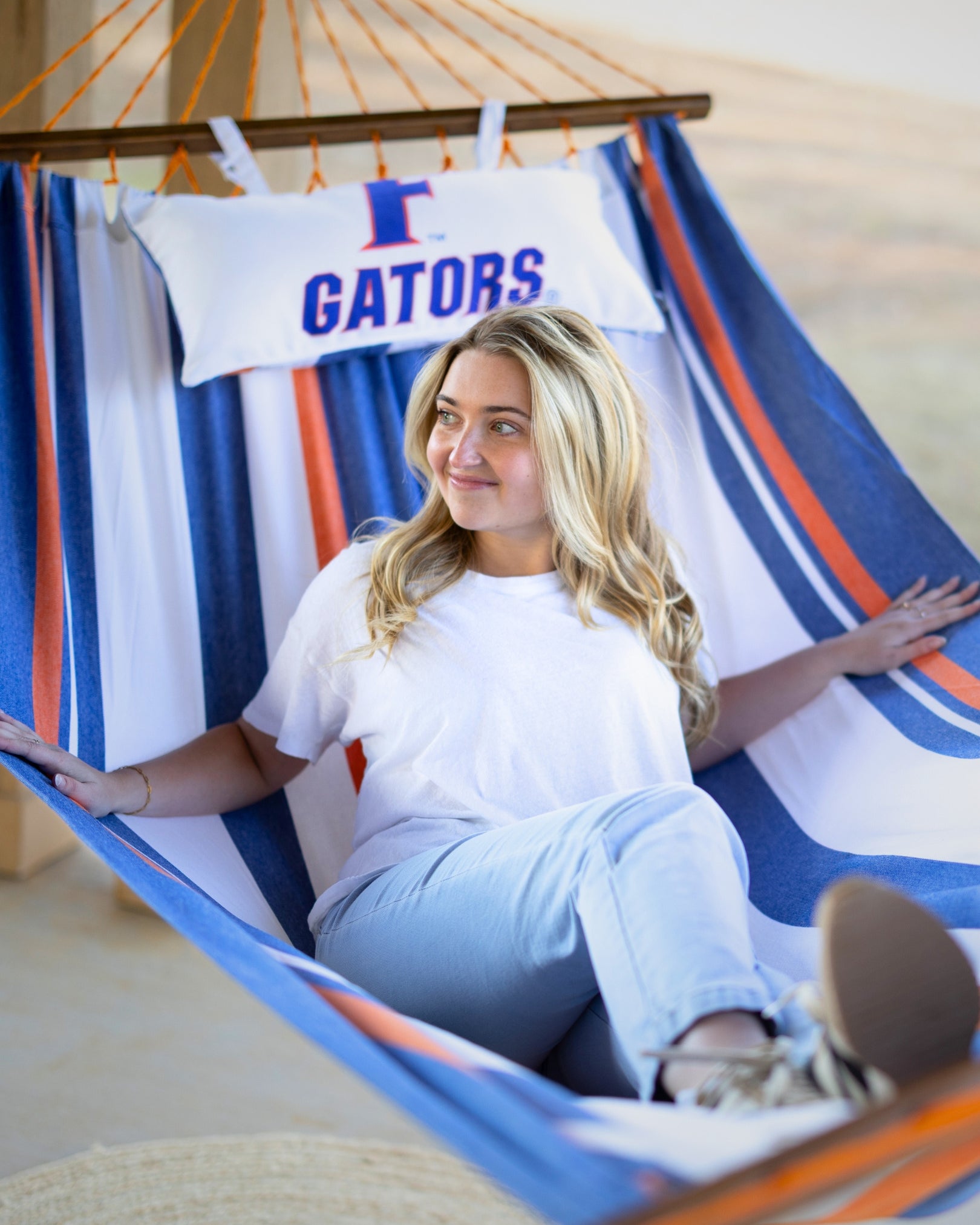 Woman sitting in a hammock with a 'Gators' banner in the background
