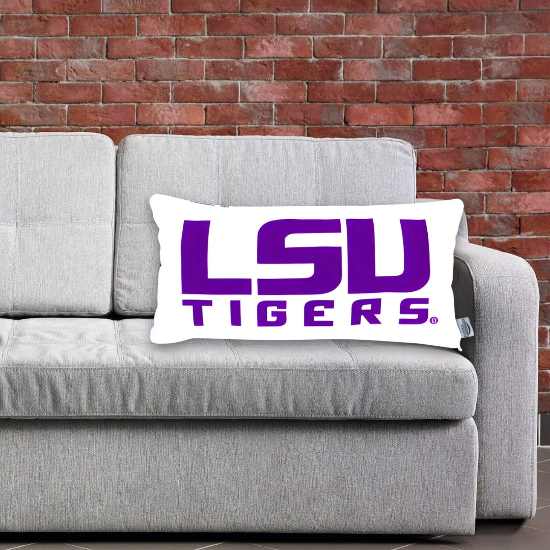 LSU Tigers lumbar pillow on a gray couch against a brick wall