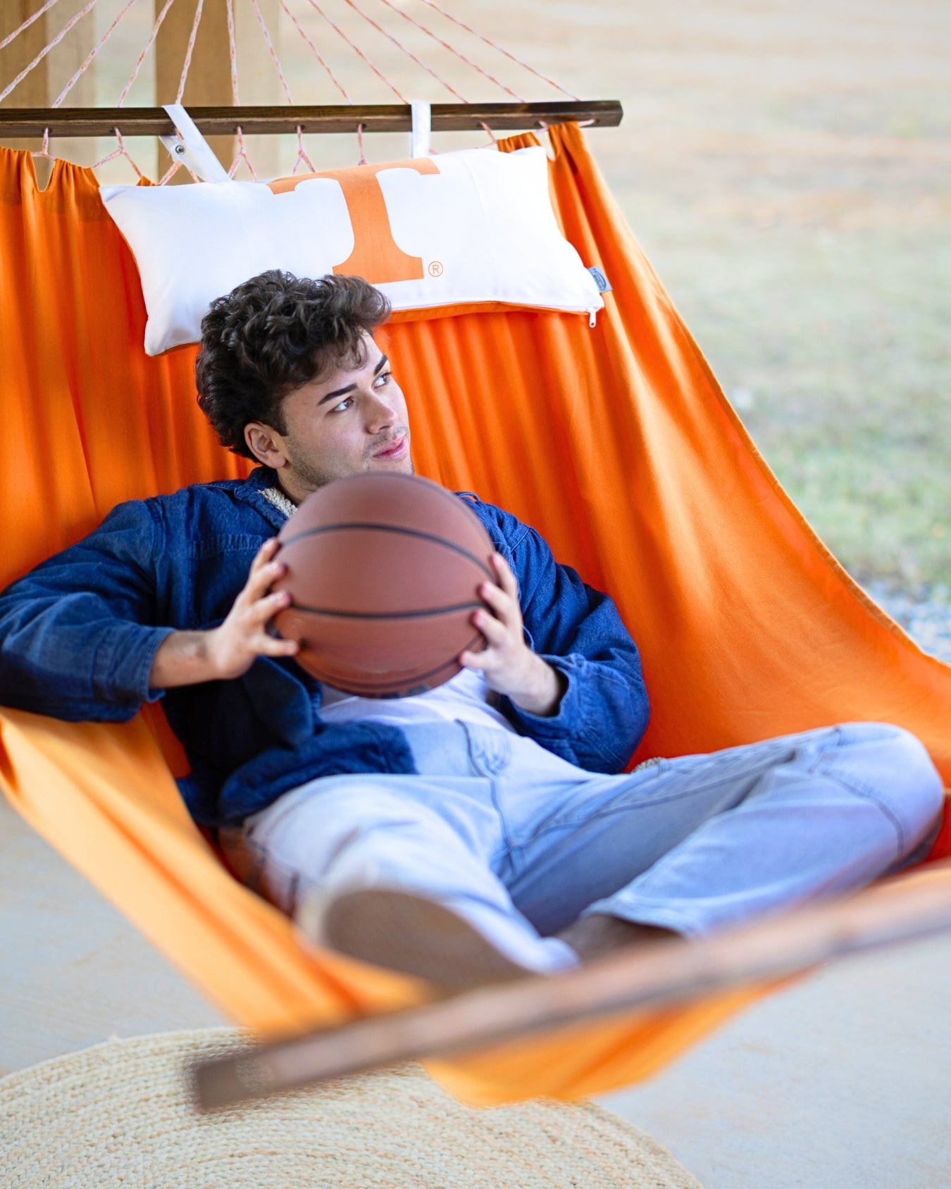Person holding a basketball in an orange Power T Tennessee logo hammock 