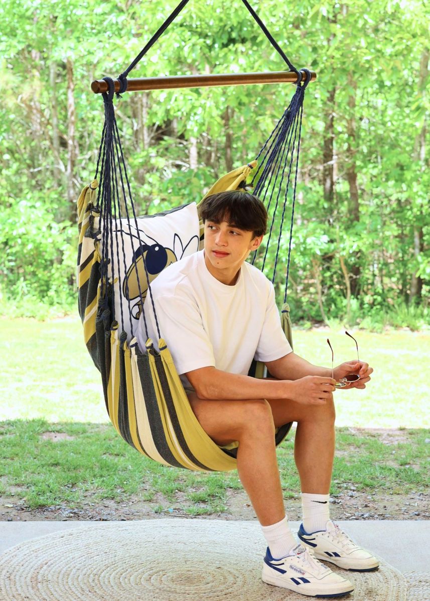 Georgia Tech Buzz hammock chair swing with a Yellow Jackets fan seated outdoors