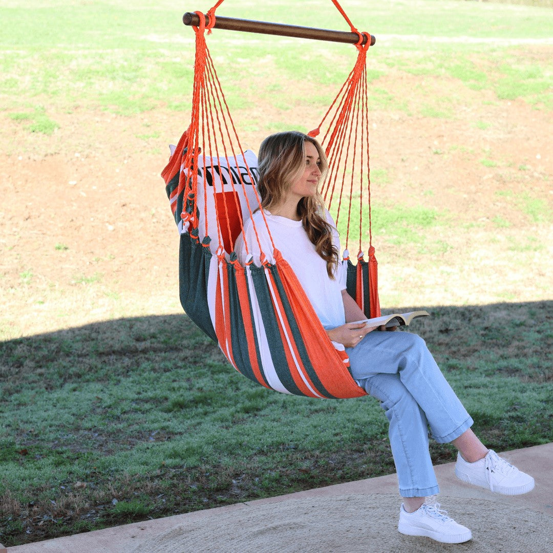 woman sitting on a Miami hurricanes chair swing outdoors patio