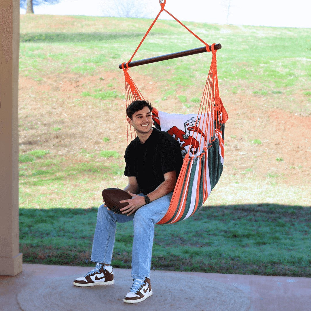 man sitting on a miami hurricanes chair swing outdoors porch