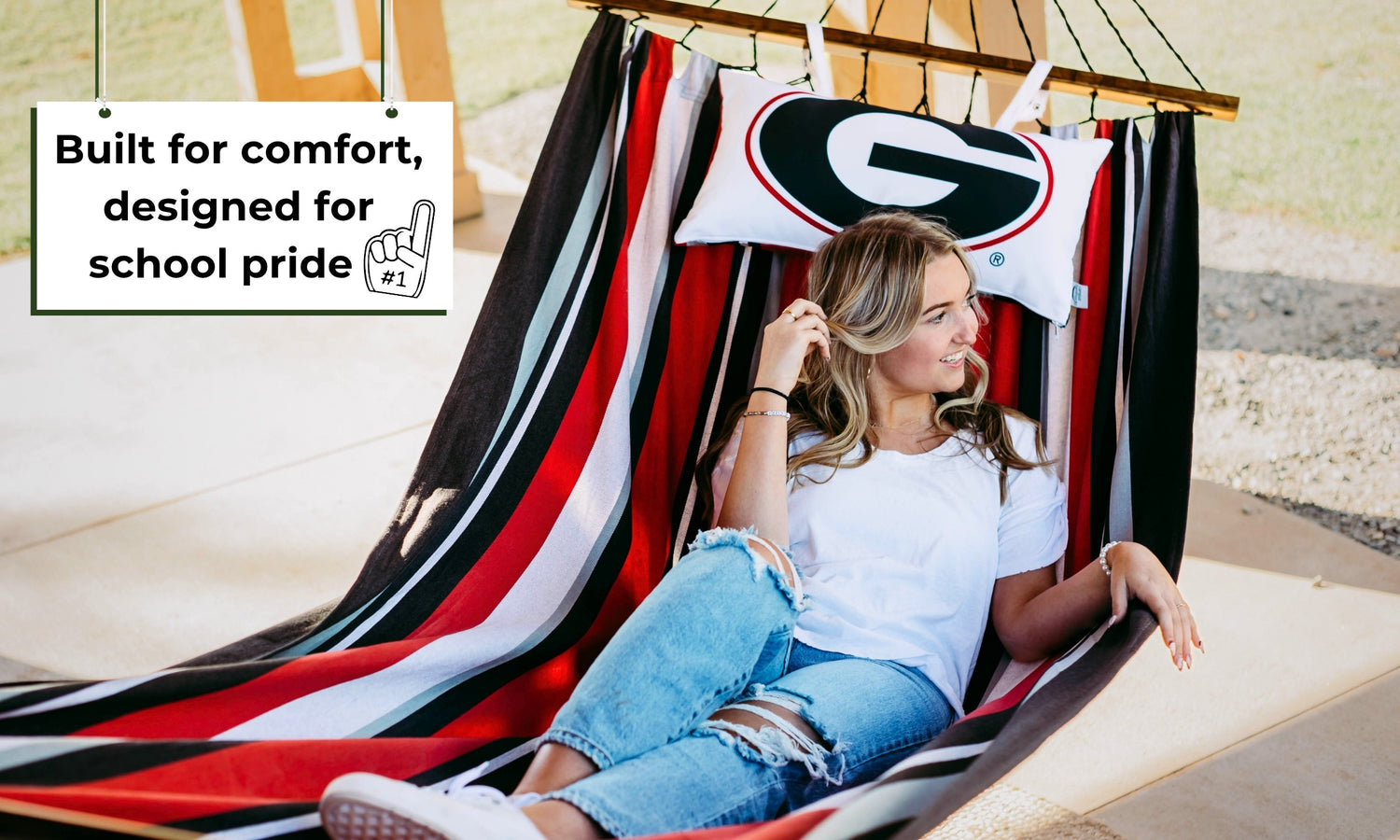 Woman relaxing in an officially licensed University of Georgia Bulldogs hammock chair with a UGA pillow.